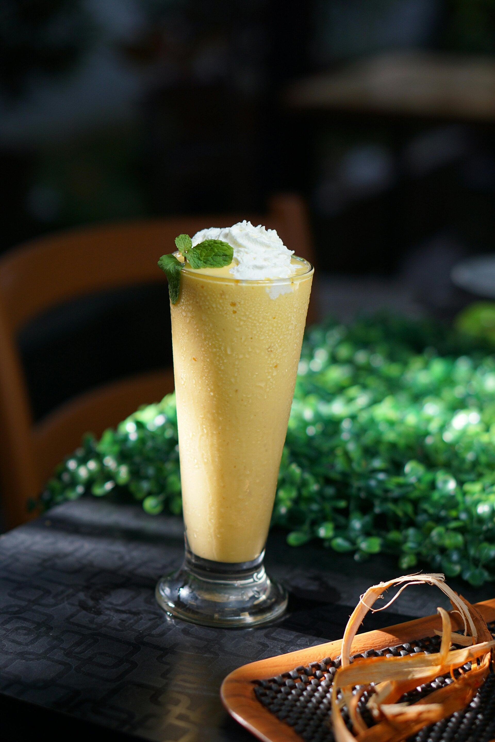 A vibrant, tropical Cannabis Mango Banana Smoothie in a glass, a perfect healthy choice for cannabis edibles and Stoner Strategies readers