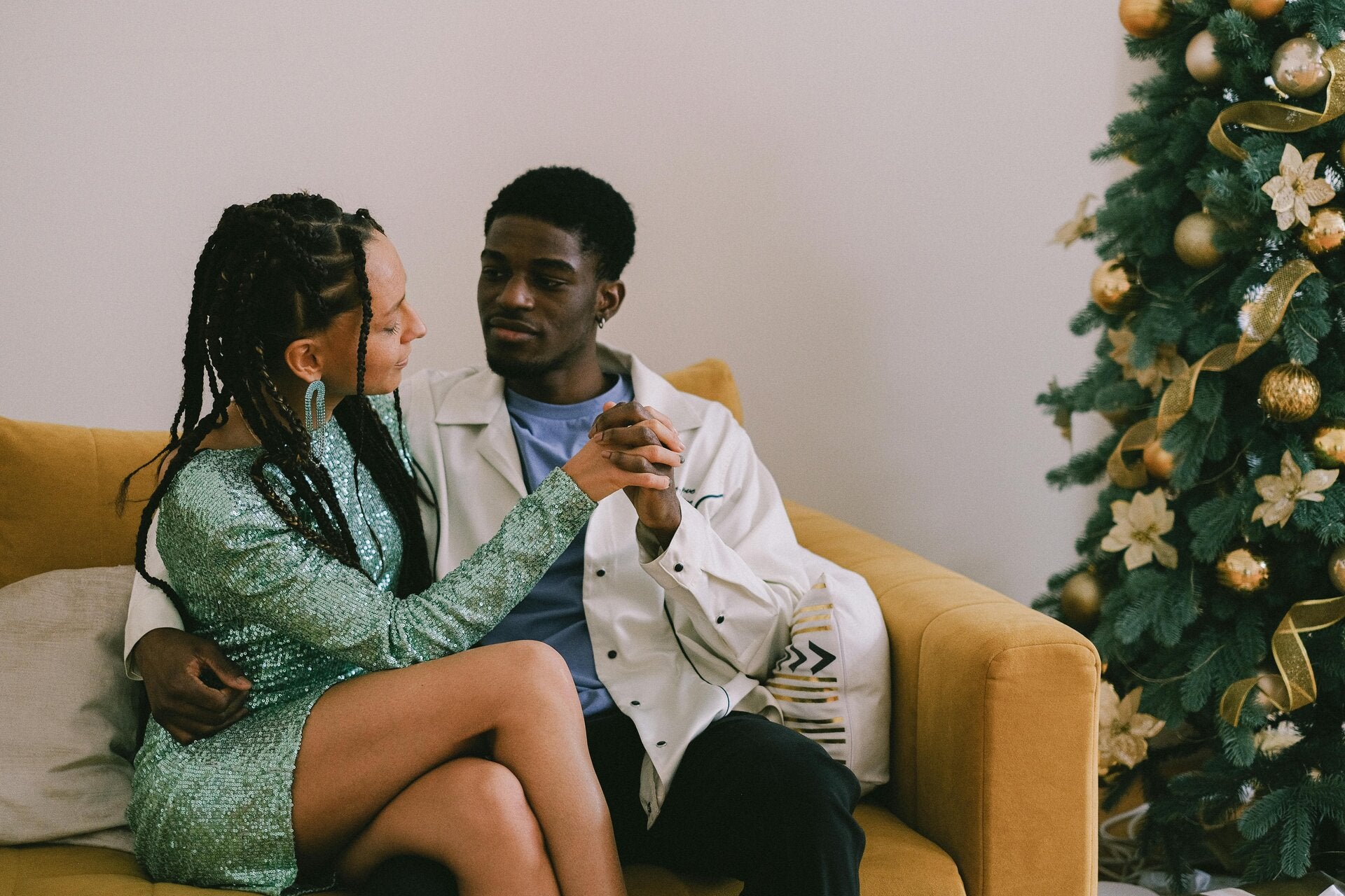 a couple sitting on a sofa with their hands entwined