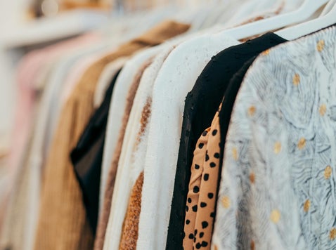 A row of neatly hung clothes swaying gently, showcasing various fabrics and colors in an organized display.