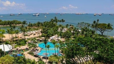 Piscine et palmiers en bord de mer à Sentosa