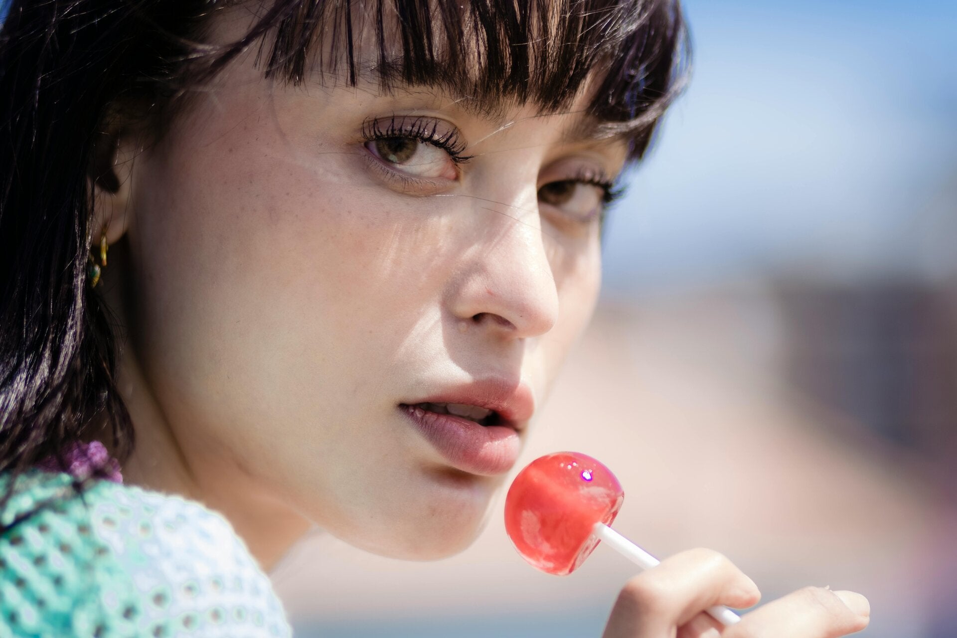 Woman and a pink lollipop a perfect treat for cannabis edibles and Stoner Strategies readers