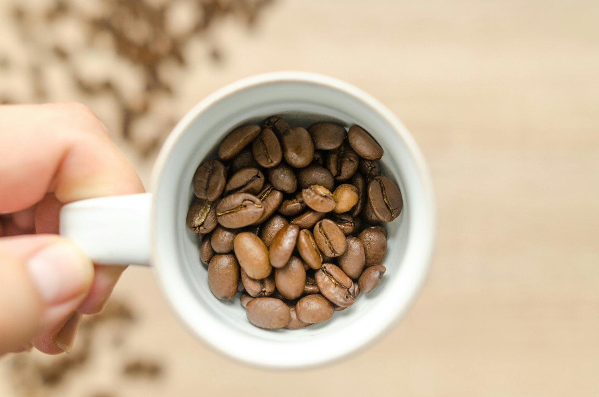 une tasse à café avec plusieurs grains de café dedans