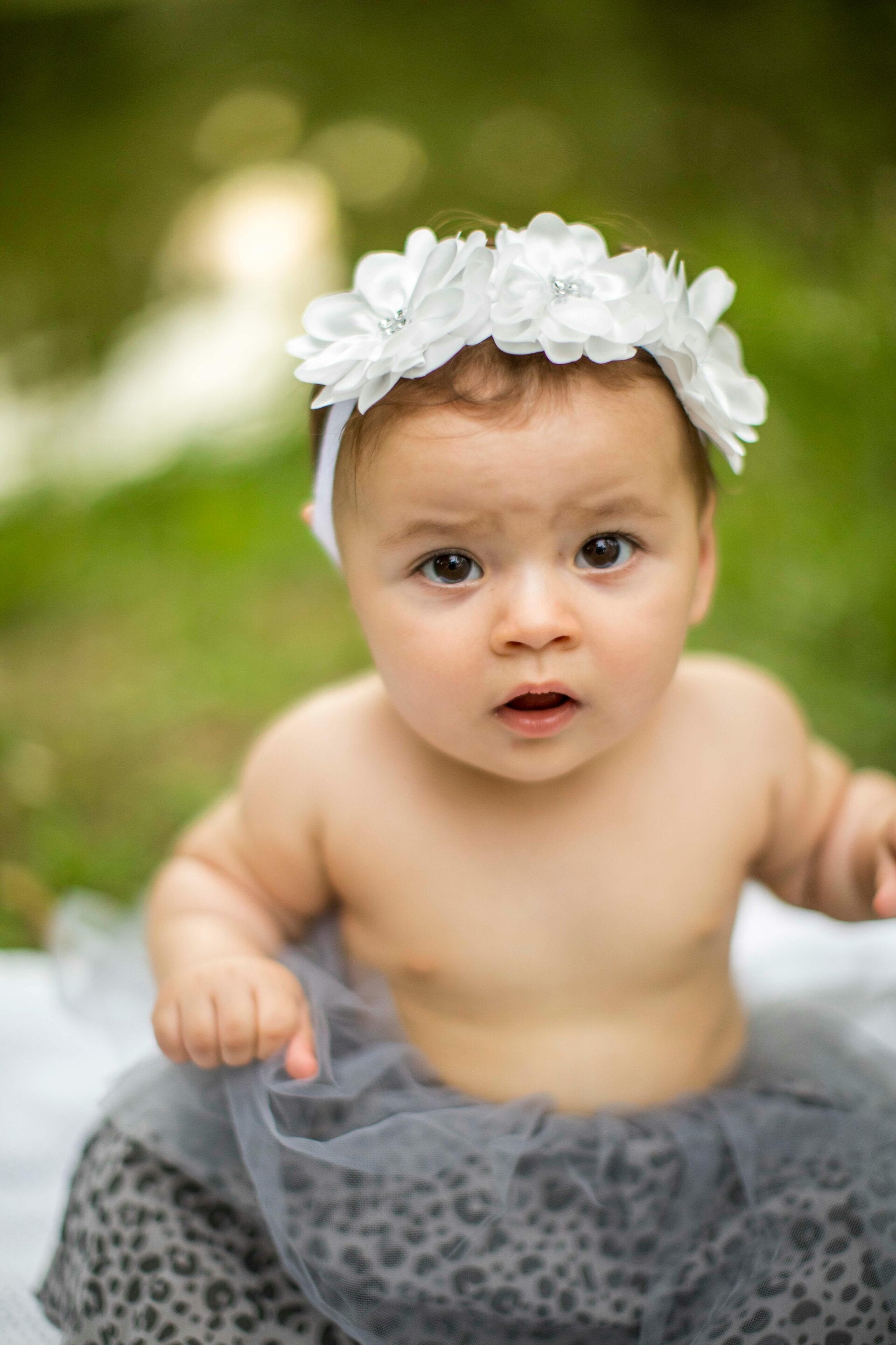Infant with a floral crown representing a sacred baby blessing ceremony and the honoring of a new soul.