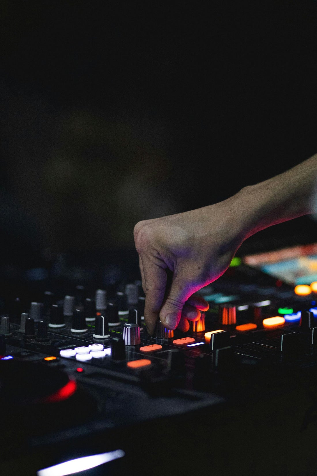 Close-up of a DJ's hand adjusting a mixing deck