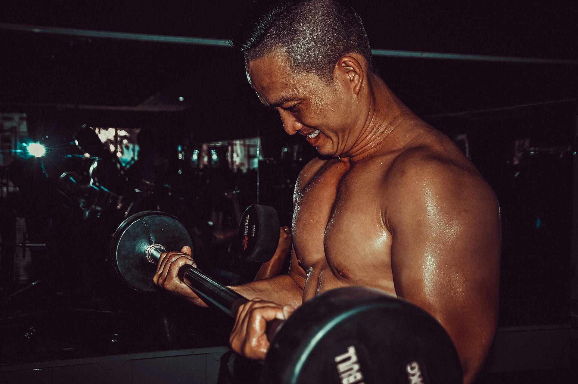un homme musclé soulevant une barre de fer avec des poids dans une salle de sport