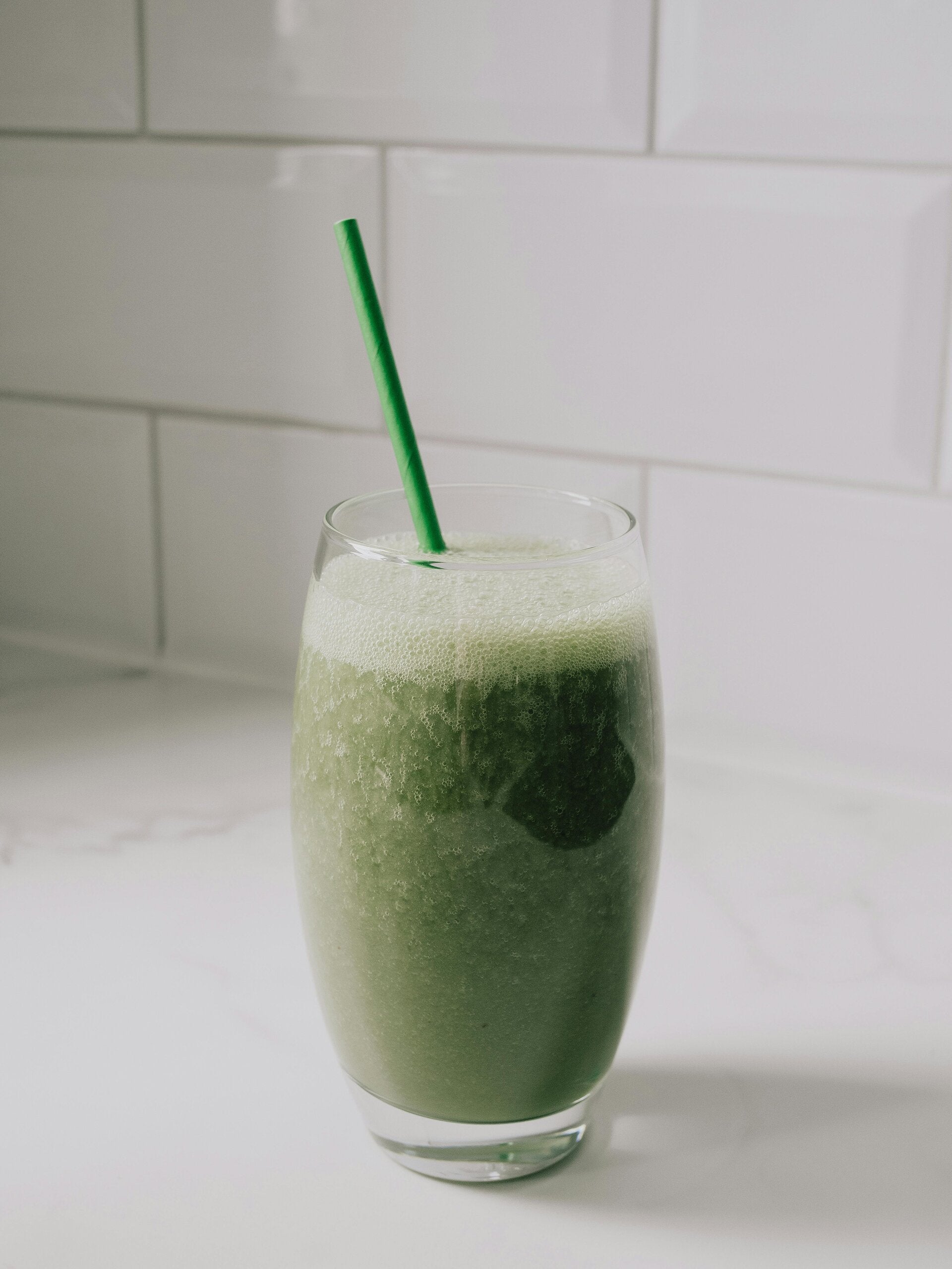 A refreshing green Cannabis Banana Spinach Smoothie in a glass, a healthy choice for cannabis edibles and Stoner Strategies fans