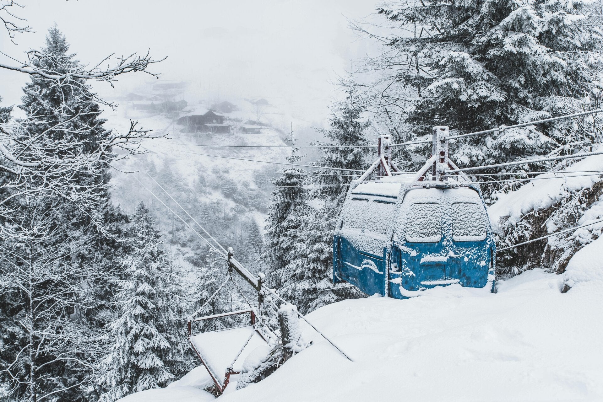 besneeuwde boomptoppen en afdalende gondels naar de apres ski