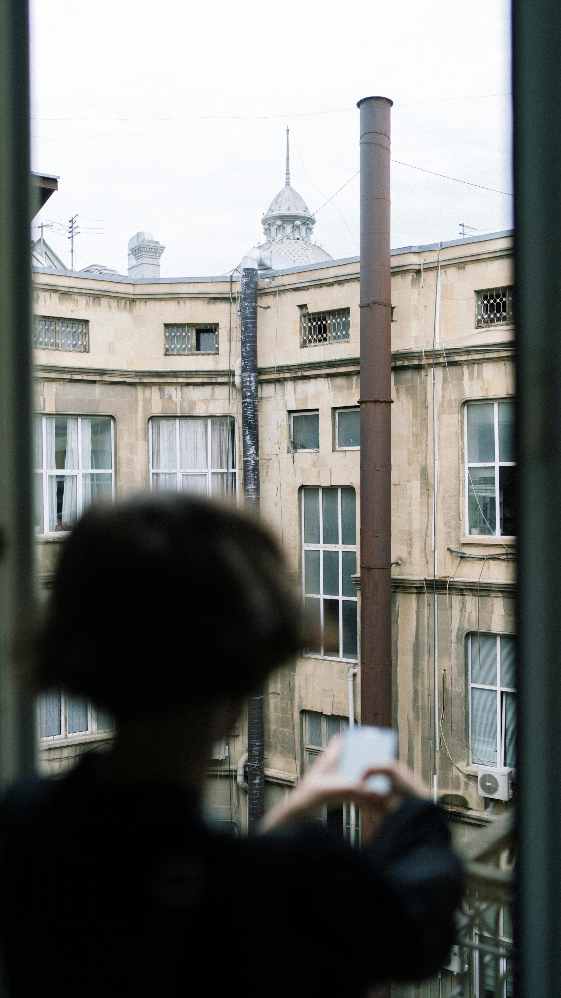 Frau schaut aus dem Fenster - Frauen in Gesundheitskrisen