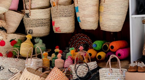 A beautiful display of hand-crafted bags and jars, skillfully woven from natural rope. Each piece showcases intricate craftsmanship, blending rustic charm with eco-friendly materials to create unique and sustainable designs