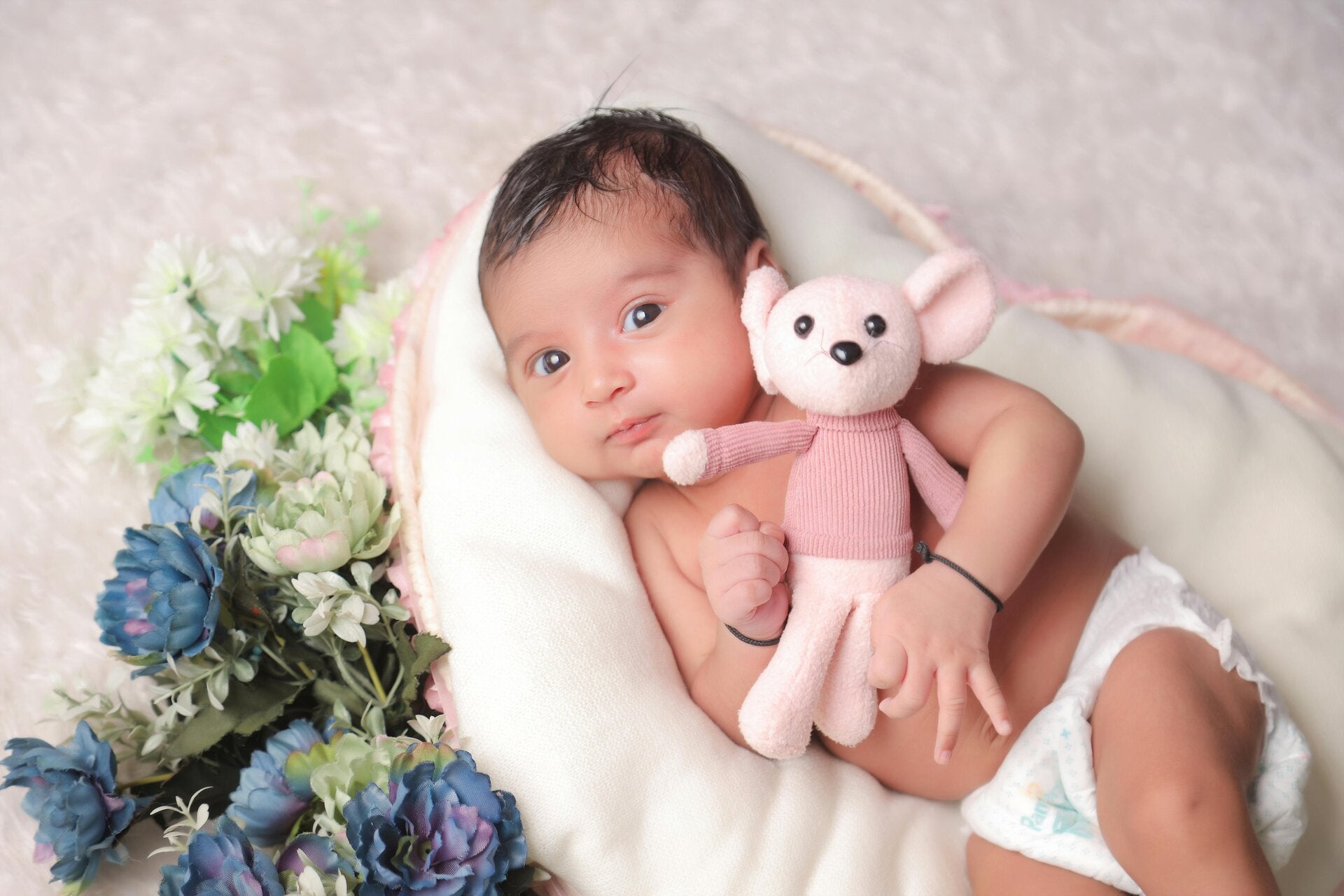 Newborn baby with a soft baby toy symbolizing sacred baby blessings, naming ceremonies, and new beginnings.