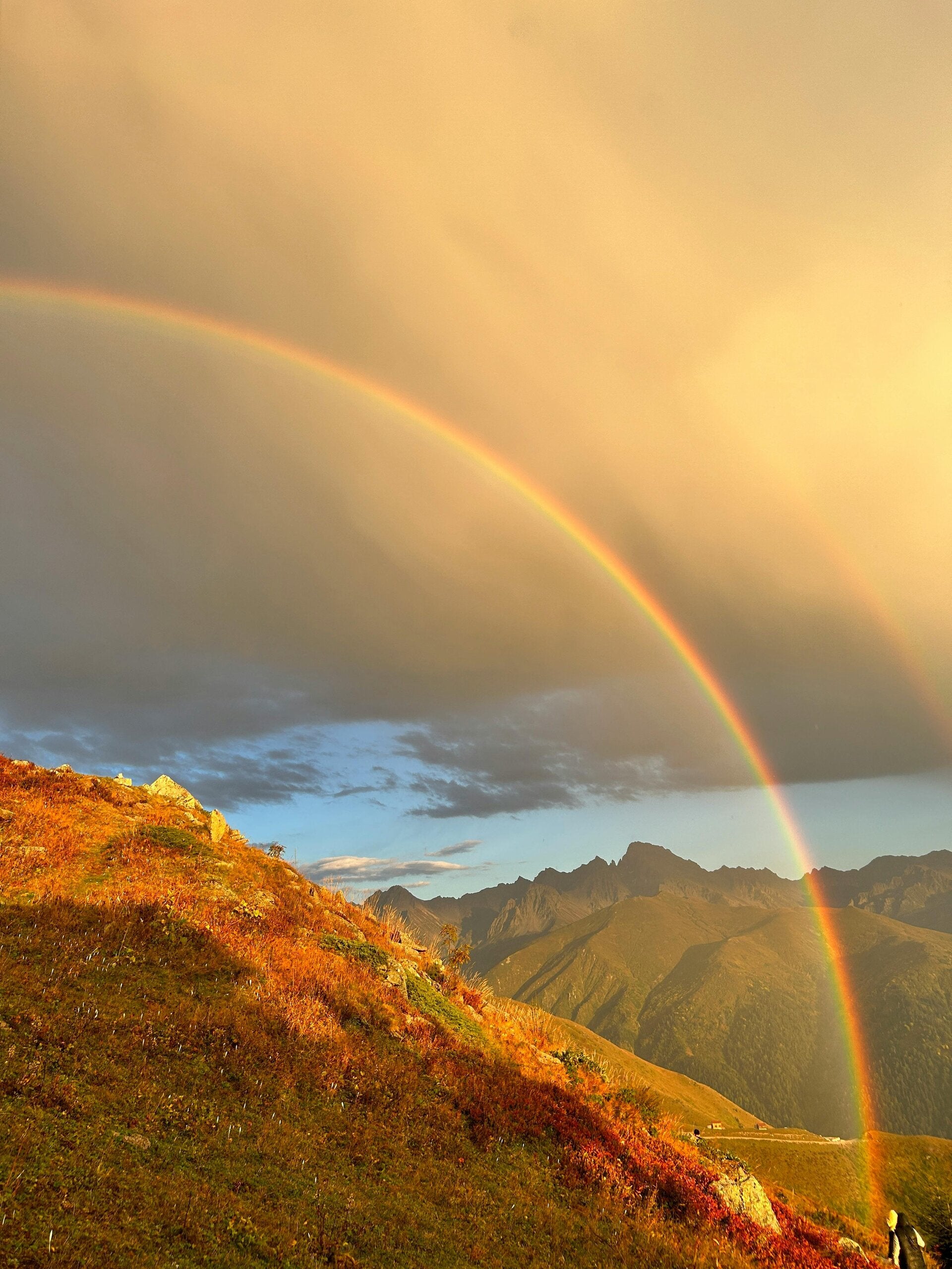 Foto van een berglandschap met een regenboog. Praktijk Hartstikkebelangrijk van coach Wendy te Woerd voor coaching en begeleiding op het gebied van rouw en verlies, burn-out, vastlopen, luisteren naar je lijf. Omgeving Arnhem, Huissen, Velp, Duiven.