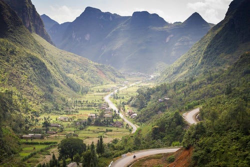 Route sinueuse dans une vallée de montagnes à Ha Giang
