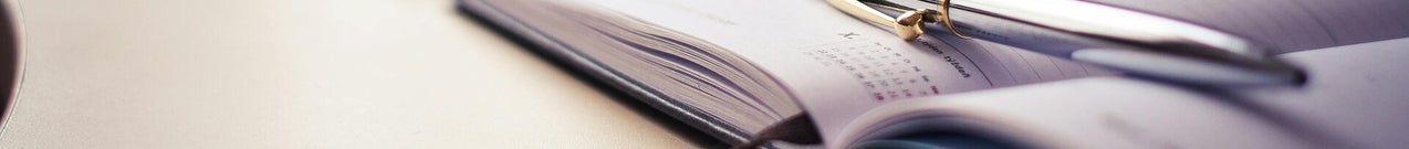 Agenda ouvert sur lequel est posé un stylo