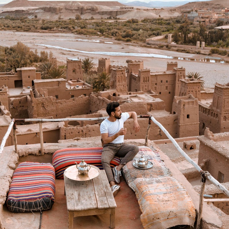 Traveler enjoying a panoramic view of Aït-Ben-Haddou from a café terrace in Morocco – authentic cultural experience with Morocco Events & Explorer.