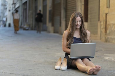Traveling professional with laptop in the street, showcasing freedom of digital nomad lifestyle