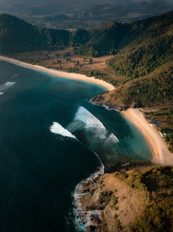Plage de sable blanc entre deux collines à Lombok