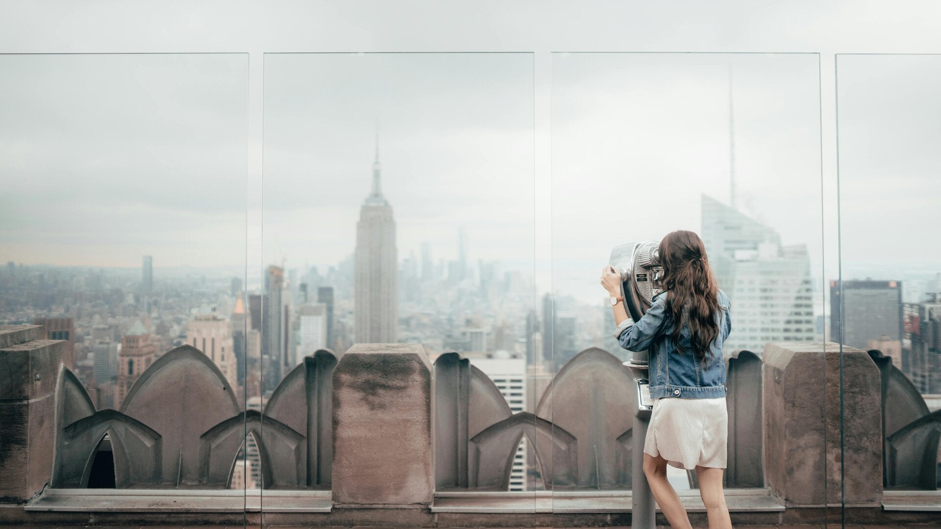 femme de dos qui regarde la vue sur new york