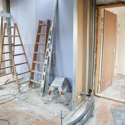 Ruimte met bouwstof, ladders en trapjes tijdens bouwschoonmaak na renovatie of nieuwbouw in Boxmeer Gemeente Land van Cuijk