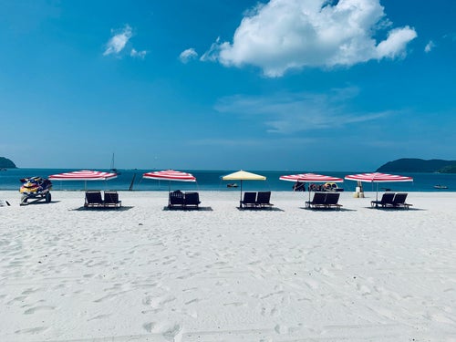Plage de sable blanc et transats à Redang