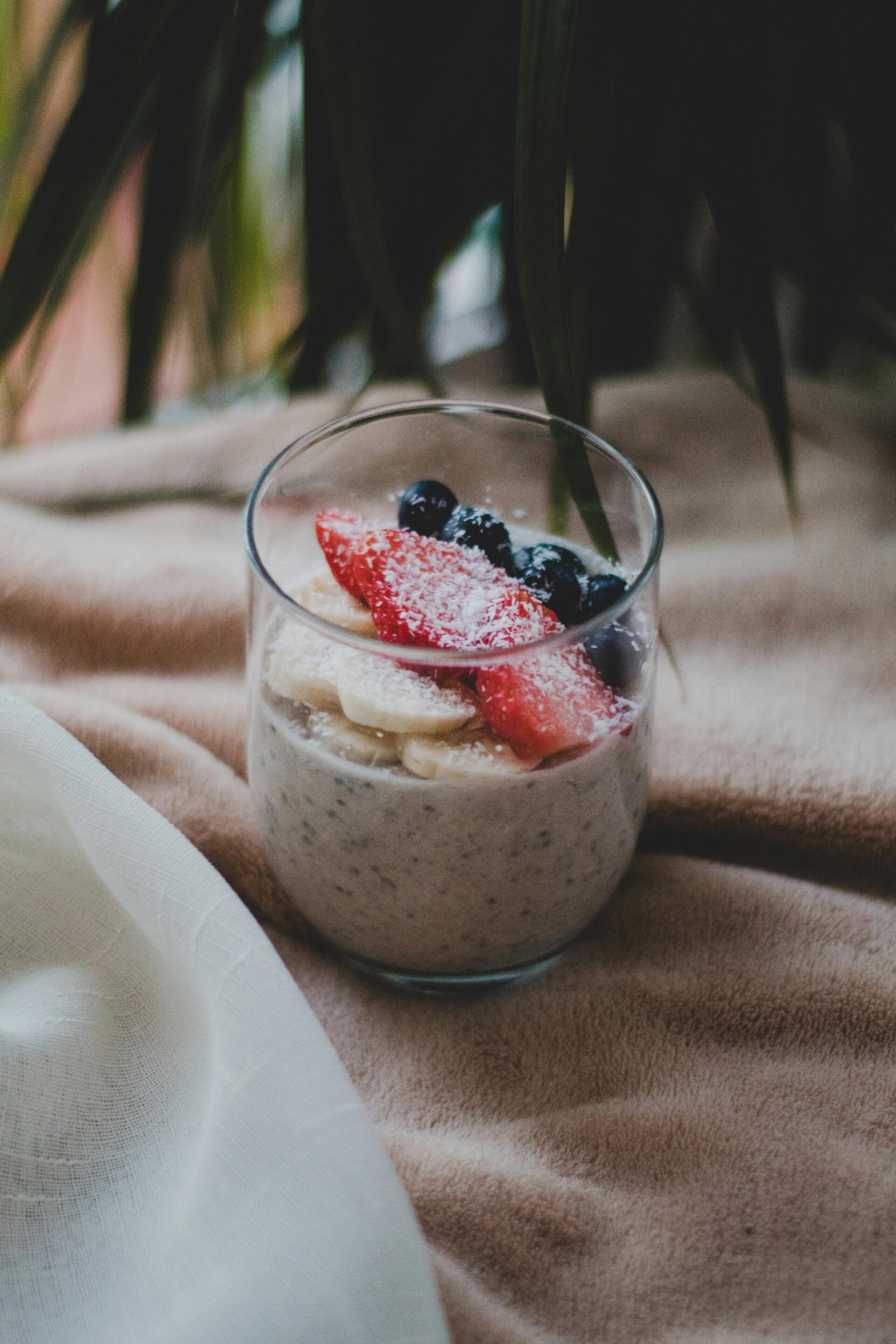 A jar of Cannabis Milk Chia Pudding topped with fresh bananas and berries, a healthy breakfast choice for cannabis edibles and Stoner Strategies readers