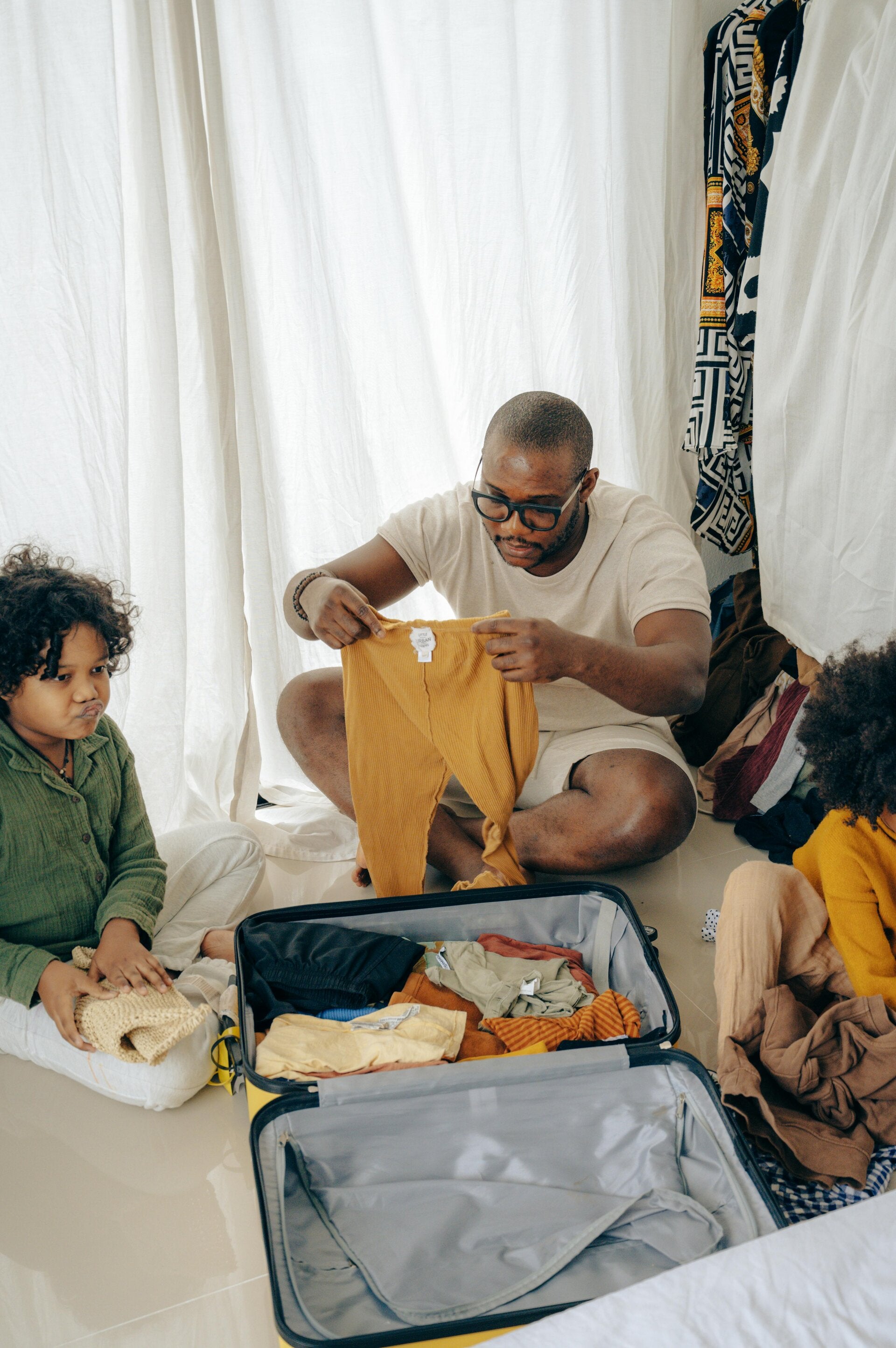 Busy family at home with laundry pile showing lack of time for folding clothes, highlighting need for professional laundry and folding service
