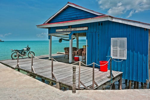 Bungalow bleu sur pilotis au bord de la mer
