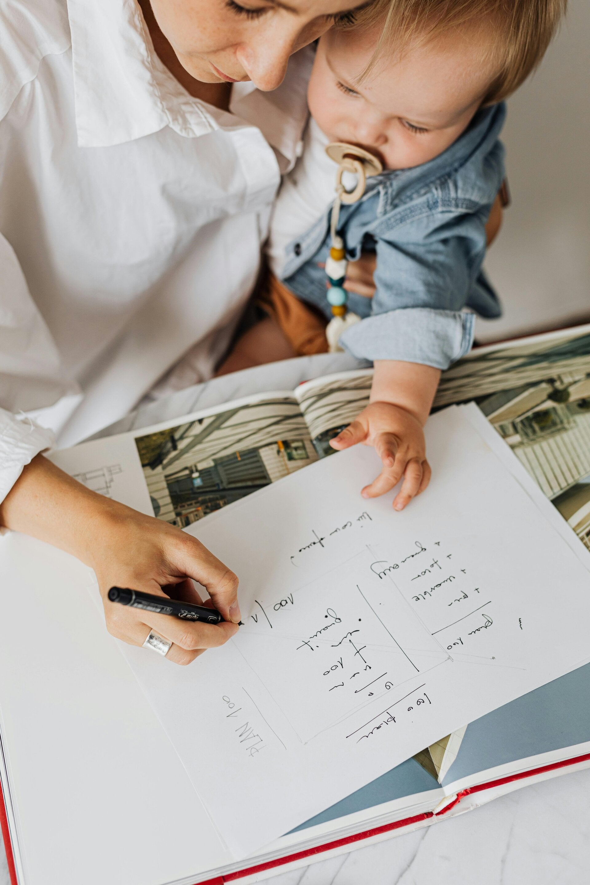 “Mother working from home while her child plays beside her — a powerful reminder of why planning ahead matters.”