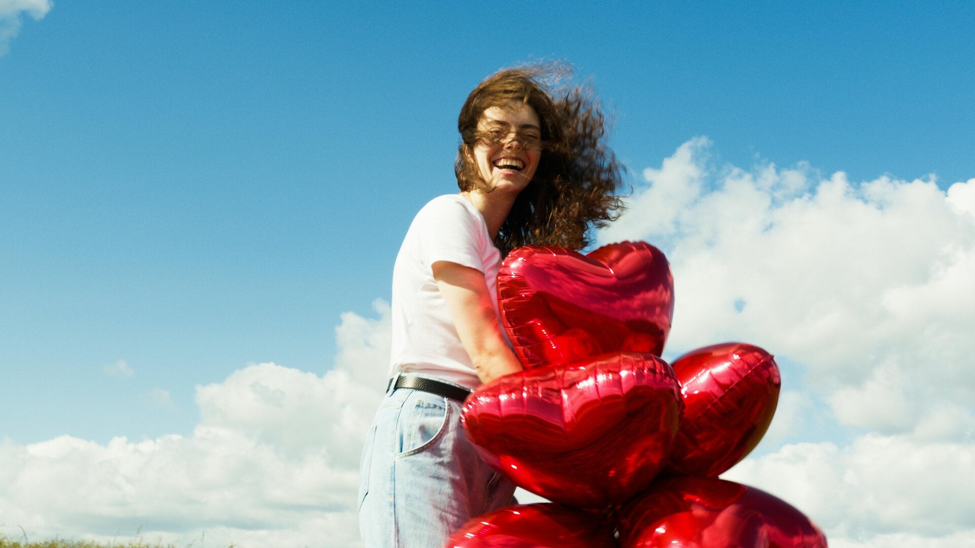Vrouw met hartjes ballonnen die ontdekt Wat is zelfliefde?  Betekenis  - Fayana Healing blog