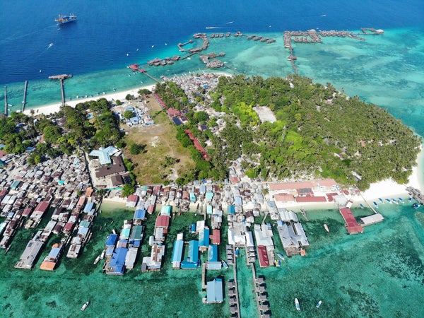 Village sur pilotis et eaux turquoise vus du ciel