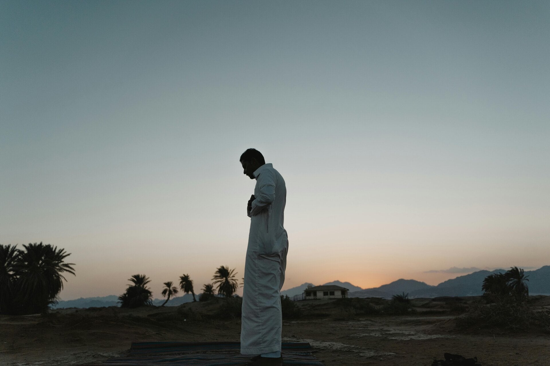 Man standing alone in nature, surrounded by trees and open sky—reflecting solitude, inner peace, and connection to the natural world.