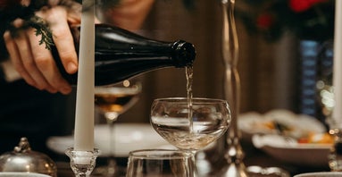 champagne pouring dow from the bottle directly into a glass