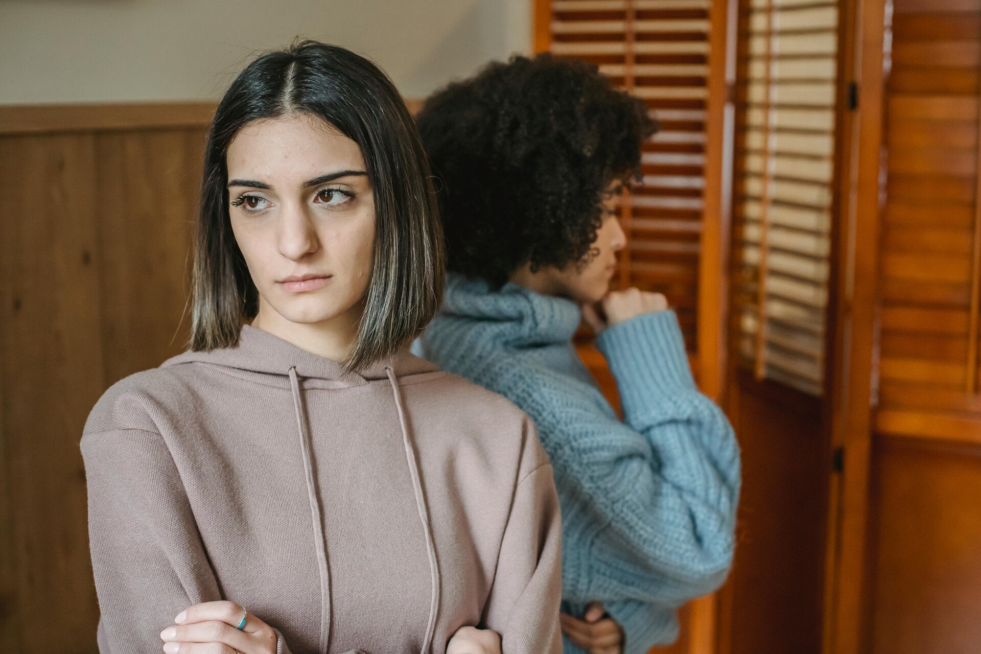 two women standing with their backs to each other