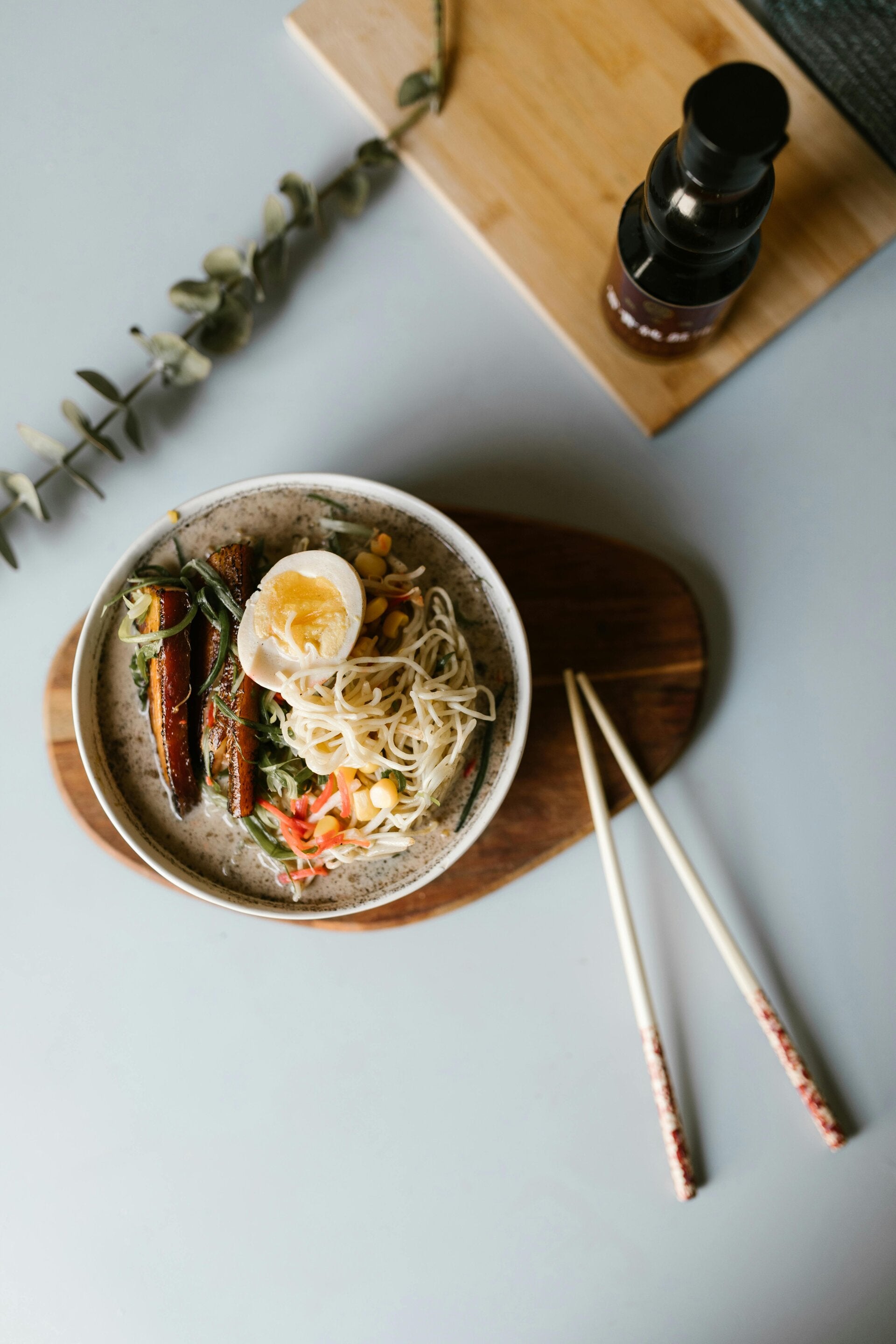 Eine Schale japanische Ramen-Suppe mit Nudeln, einem halbierten Ei, Frühlingszwiebeln und Nori-Algenblatt.