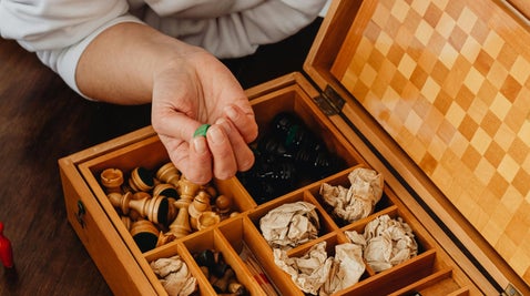 An engaging scene featuring a box filled with colorful game pieces, held by a player preparing for a match