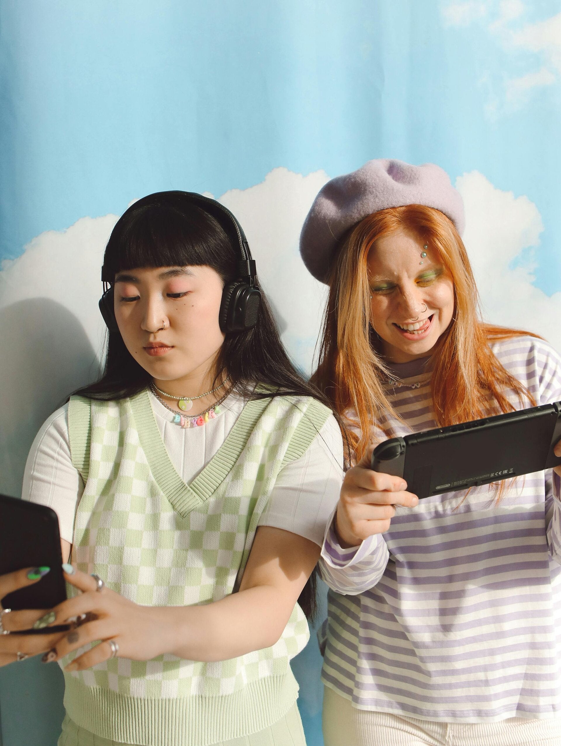 Due giovani donne giocano con smartphone e console, tecnologia e salute mentale, interazione digitale.