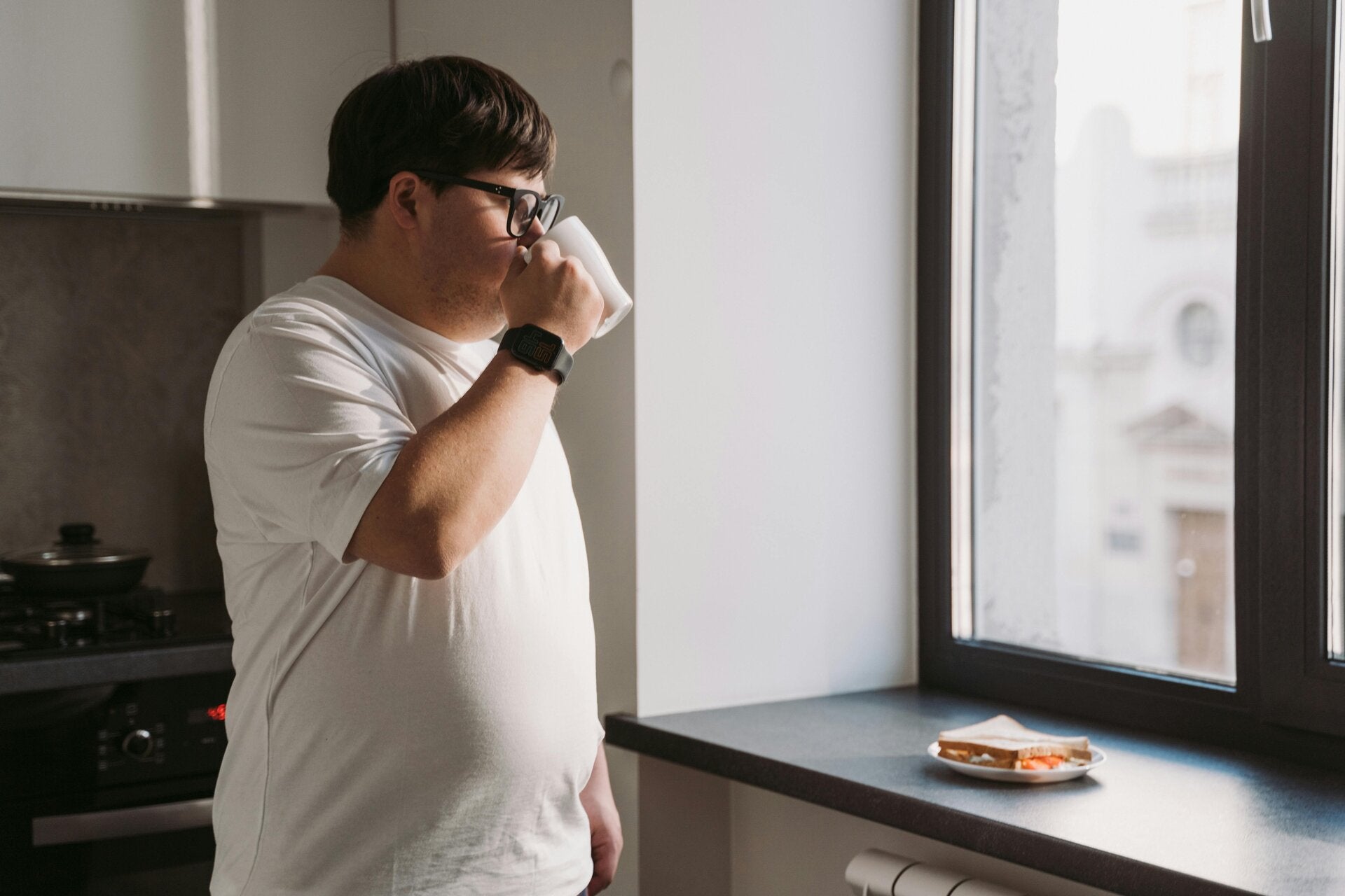 Une personne concentrée sur la perte de poids, avec une assiette de nourriture saine repose sur le rebord de la fenêtre.