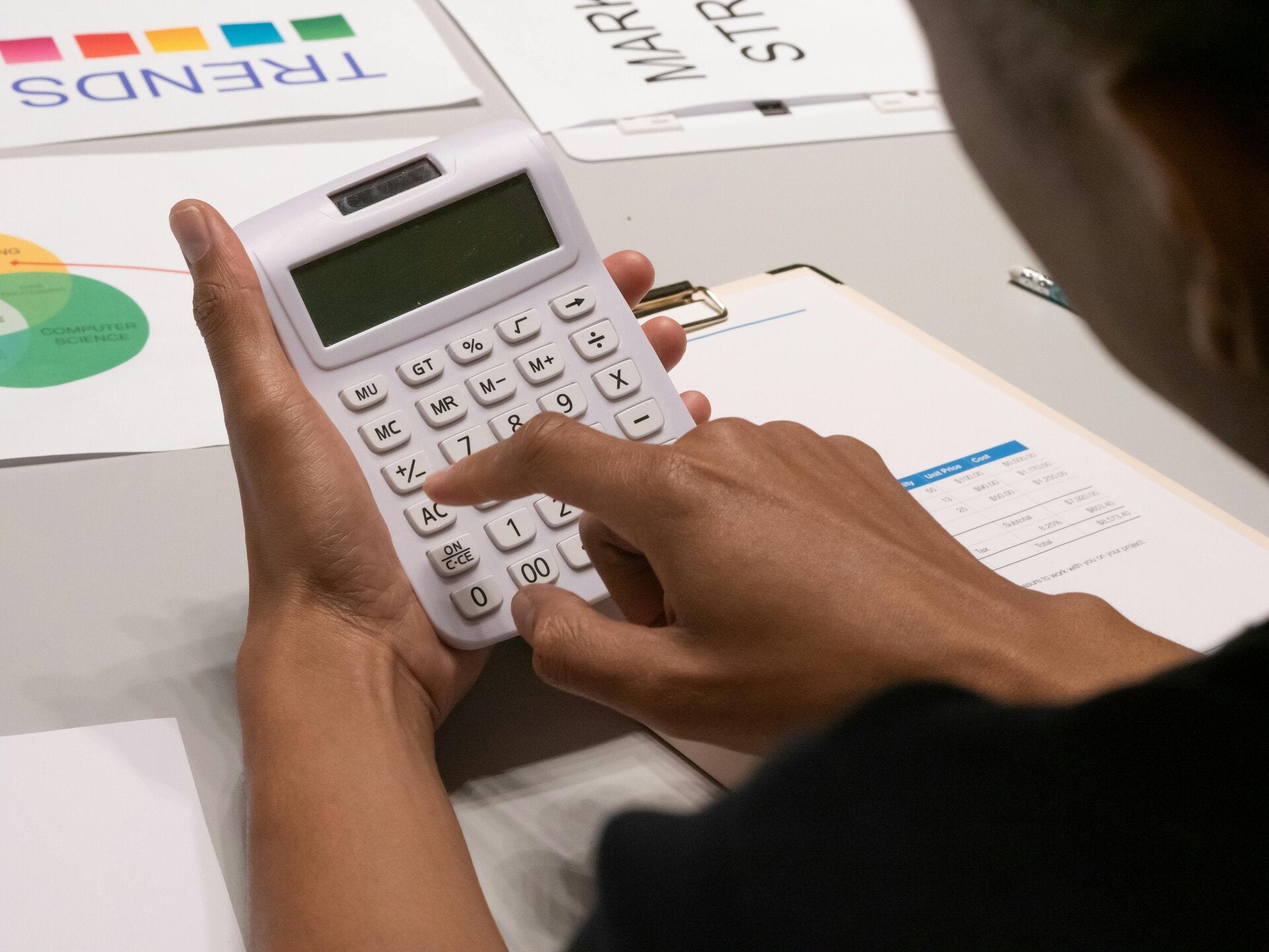 Une personne qui calcule a l'aide d'une calculatrice