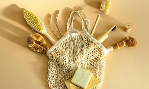 A collection of eco-friendly brushes, crafted from recycled materials, neatly placed inside a sustainable bag. Each brush showcases creative repurposing, blending functionality with environmental responsibility.