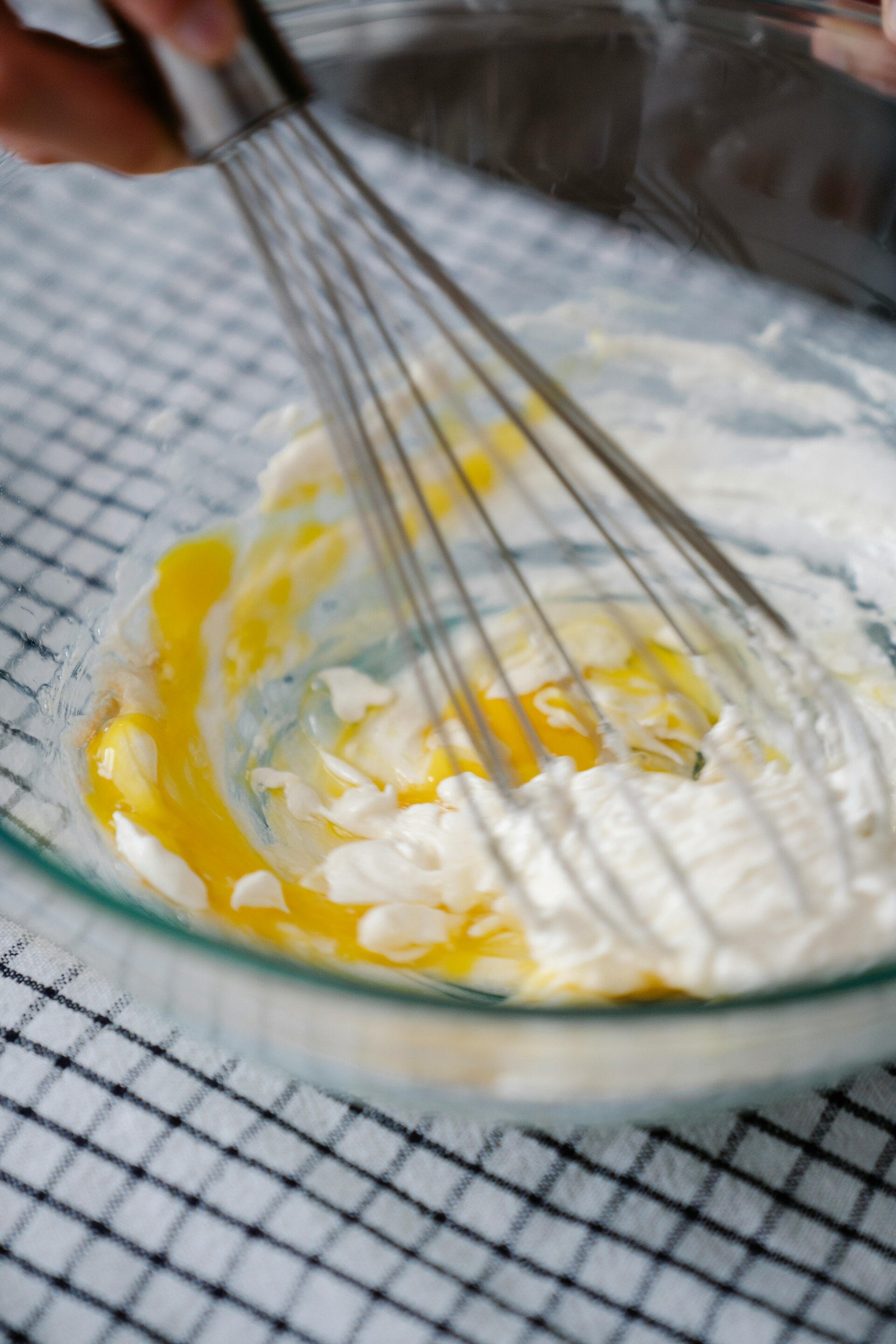 A glass bowl with a whisk making cannamayo