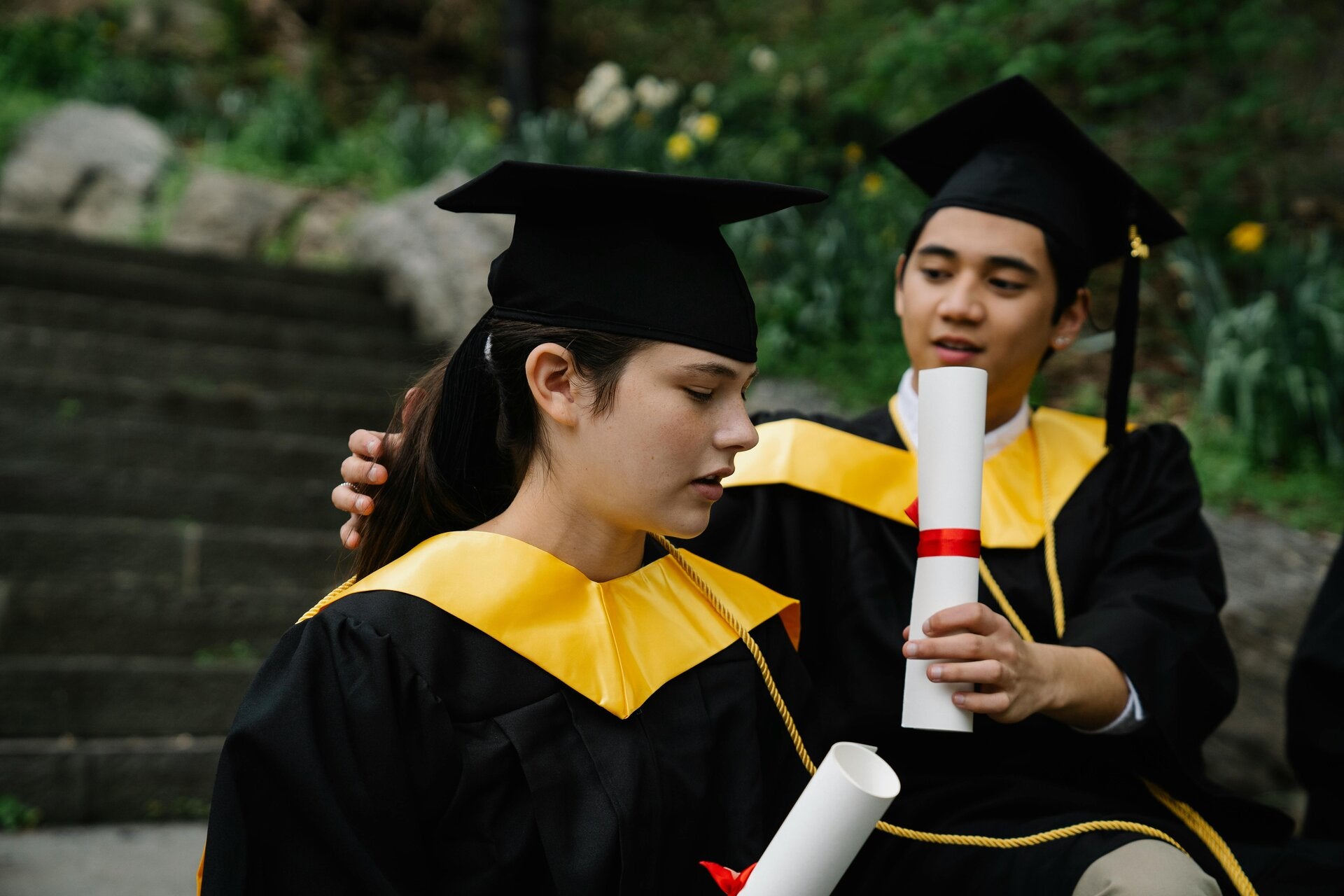 Graduates holding diplomas outdoors, illustrating opportunities through funded education