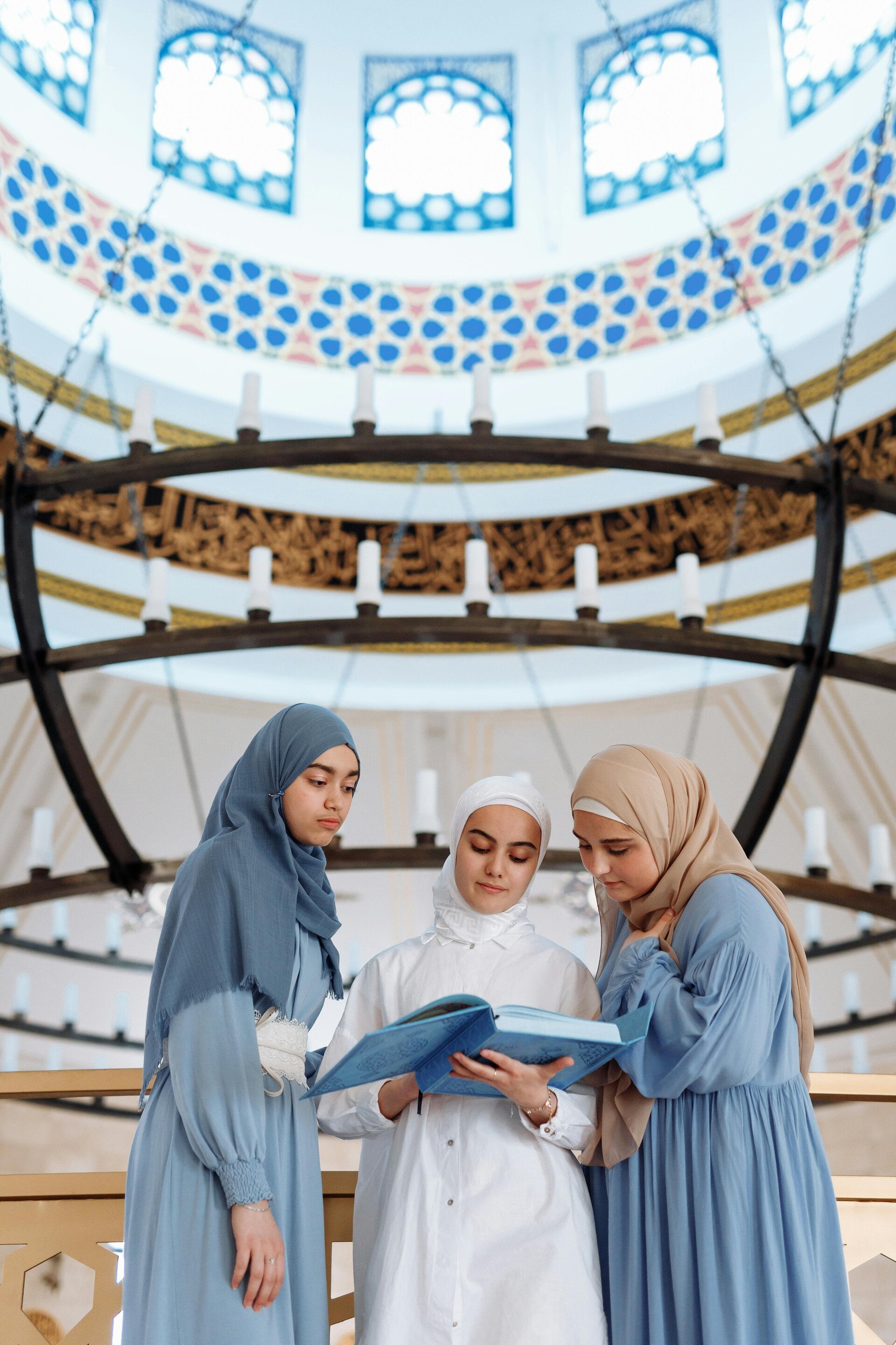 Group of three Muslim women reading together inside a beautiful mosque in Wolverhampton, reflecting themes of Islamic counselling and community support