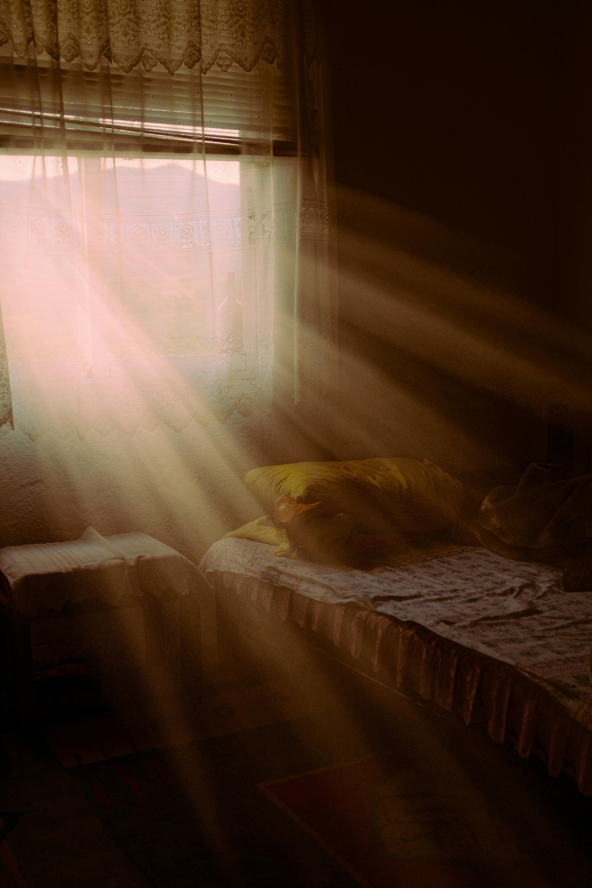 Soft morning sunlight beaming through a bedroom window, casting a warm glow across the room and symbolizing clarity, renewal, and spiritual awakening.