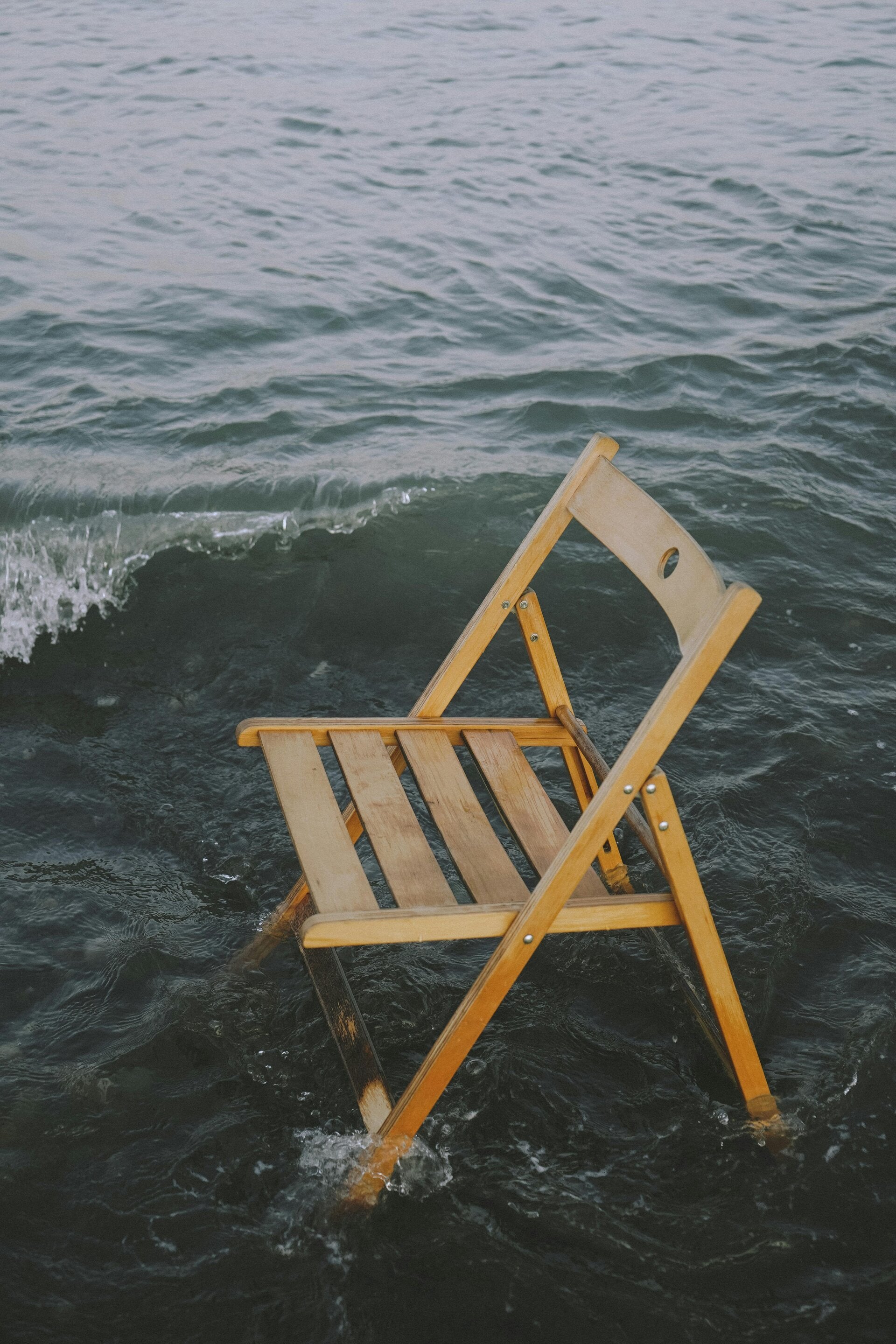 Houten Stoel die in het water staat als metafoor voor systemisch werken en onderzoeken of je op de juiste plek staat.