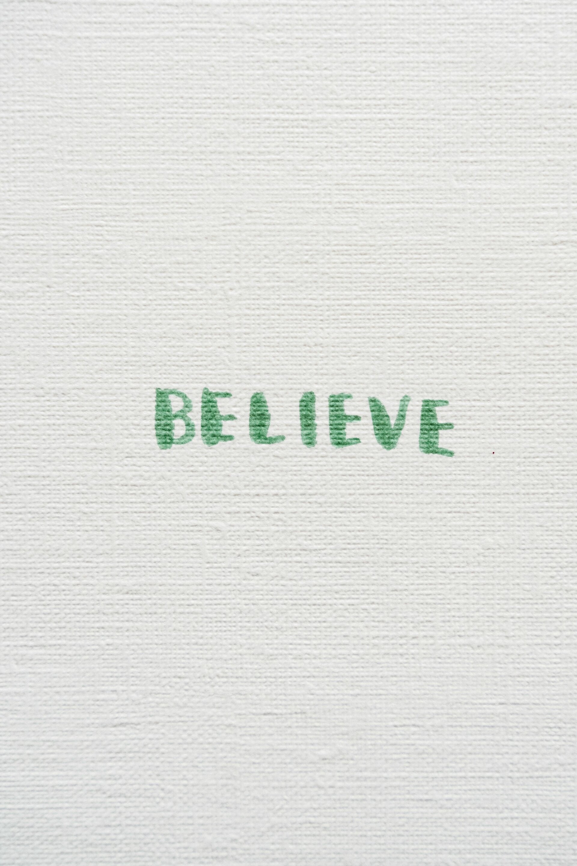 op wit papier in groene letters staat believe