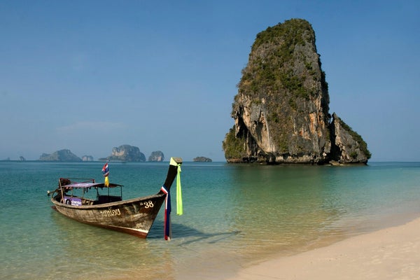 Bateau longtail devant un piton calcaire à Krabi