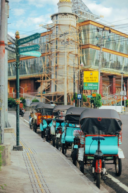 Becaks alignés dans une rue de Yogyakarta