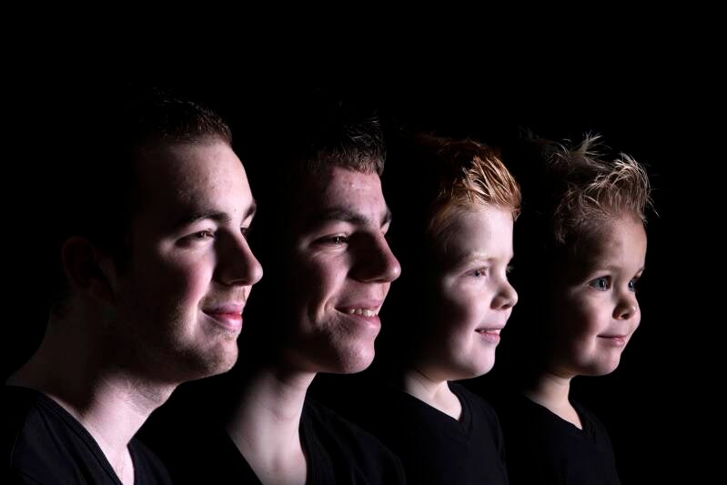 4 broers op de foto met een zwarte achtergrond. De kleurenfoto is gemaakt door fotograaf Johan Bouwmans uit Deurne. 