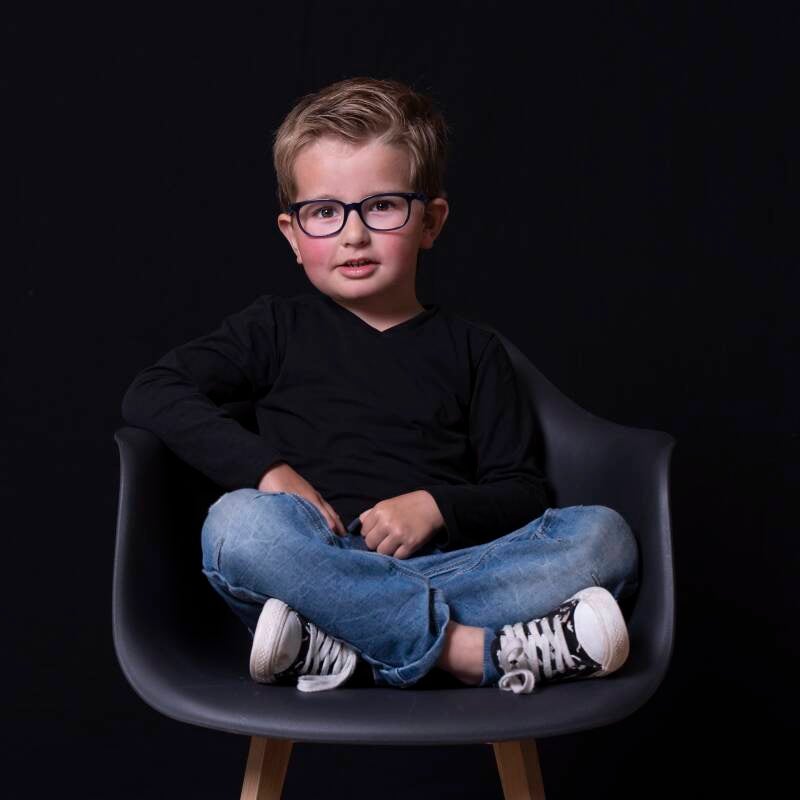 Tom liet zich prima fotograferen in een stoel van de Action. Door de zwarte fotoachtergrond creeer ik een low key setting die het fotomodel mooi naar voren brengt.