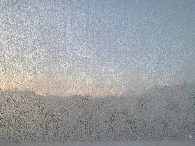 IJskristallen op het raam met daarachter een dakrand