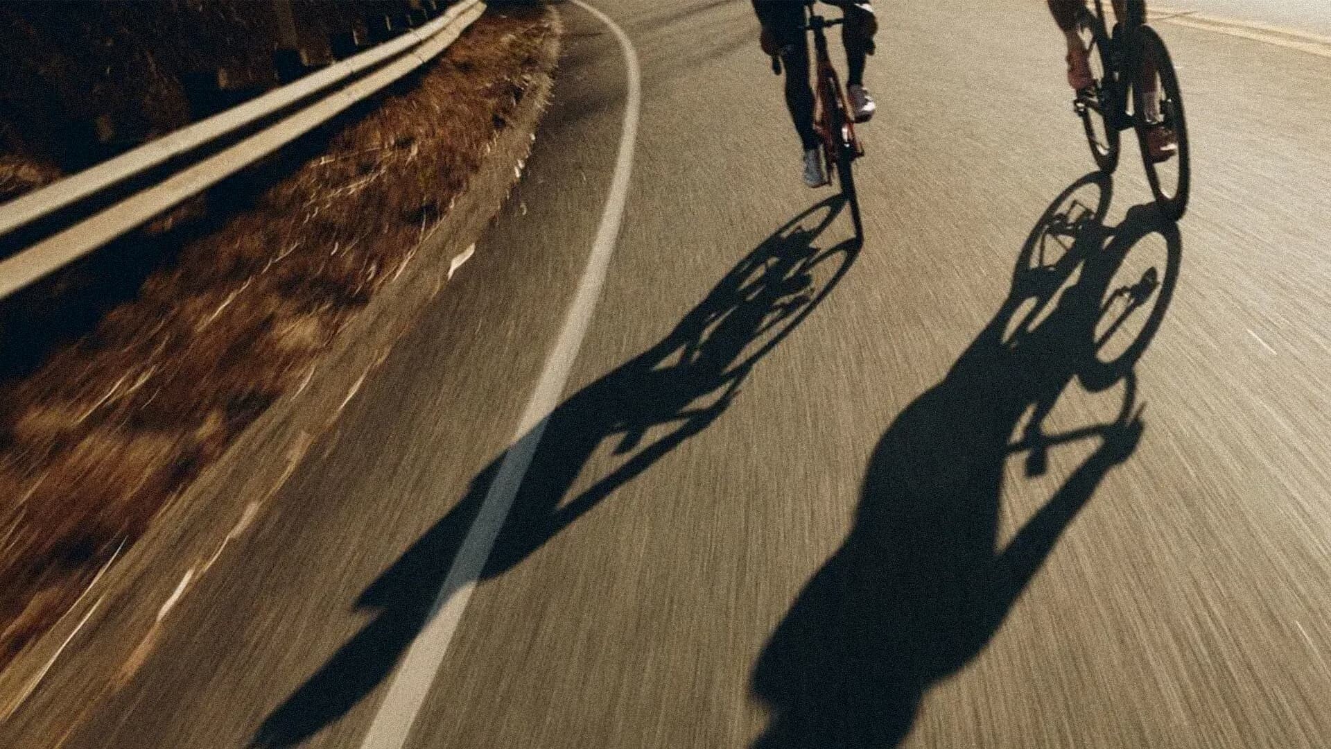 Twee wielrenners op de racefiets in het avondlicht